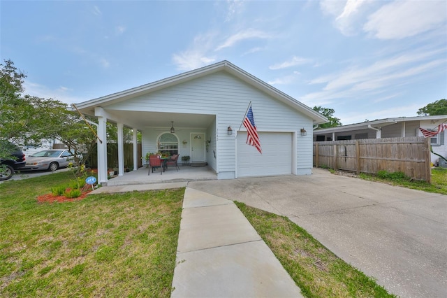 view of front facade with covered porch, fence, a front lawn, concrete driveway, and an attached garage