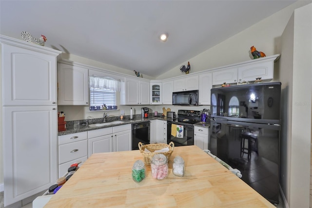 kitchen featuring lofted ceiling, white cabinetry, glass insert cabinets, a sink, and black appliances