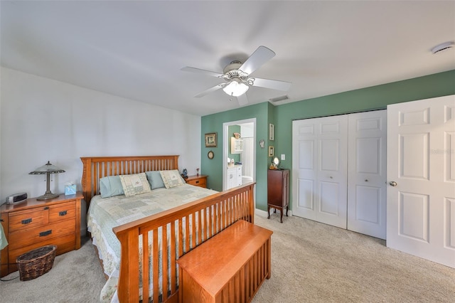 bedroom with ensuite bath, light colored carpet, a closet, visible vents, and a ceiling fan