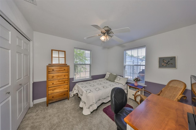 carpeted bedroom featuring a closet, a ceiling fan, and baseboards