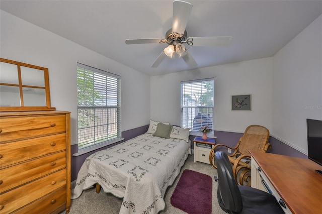 bedroom with multiple windows, ceiling fan, and carpet floors