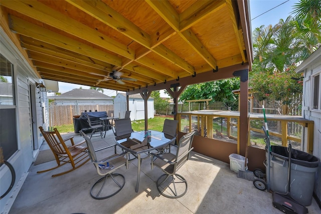 view of patio / terrace featuring an outdoor structure, a playground, a storage unit, outdoor dining space, and a fenced backyard