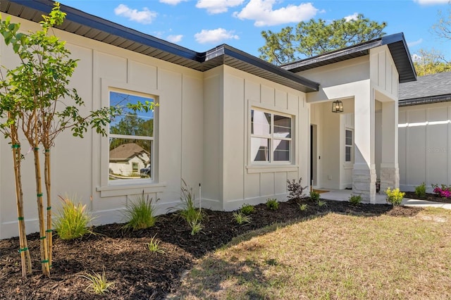 exterior space with board and batten siding and a lawn