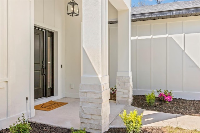 property entrance featuring board and batten siding and roof with shingles