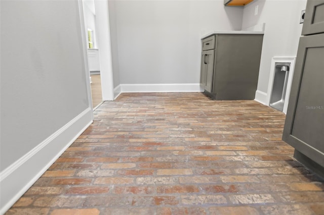 interior space featuring baseboards and brick floor
