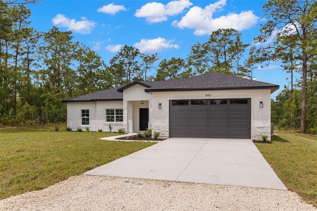 view of front of property with a front lawn, stone siding, a shingled roof, an attached garage, and driveway