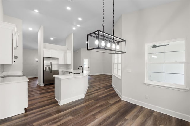 kitchen featuring dark wood finished floors, a sink, stainless steel fridge with ice dispenser, baseboards, and white cabinetry
