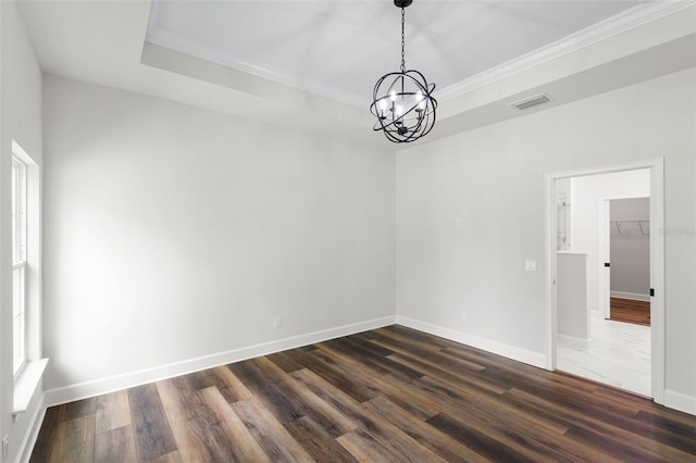 spare room featuring dark wood-style flooring, a chandelier, baseboards, visible vents, and ornamental molding