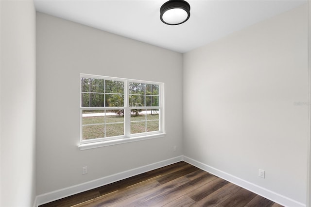 empty room with baseboards and dark wood-style floors