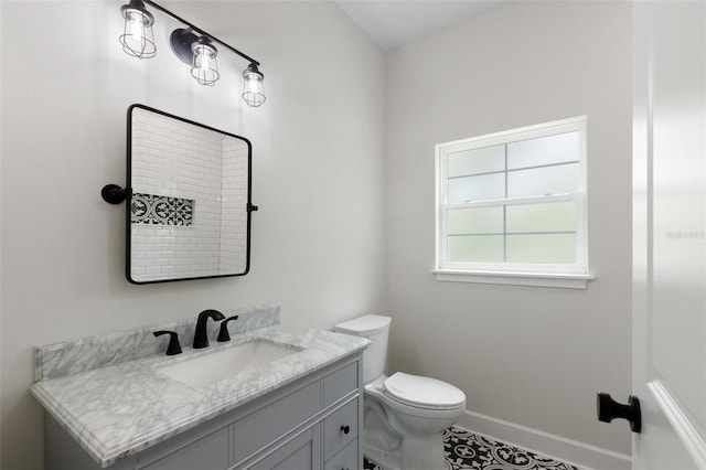 bathroom featuring toilet, baseboards, tile patterned flooring, and vanity