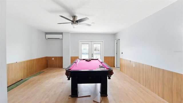 4396 5th Isle Dr, Hernando Beach, FL 34607 - recreation room featuring an AC wall unit, wood walls, french doors, and a wainscoted wall