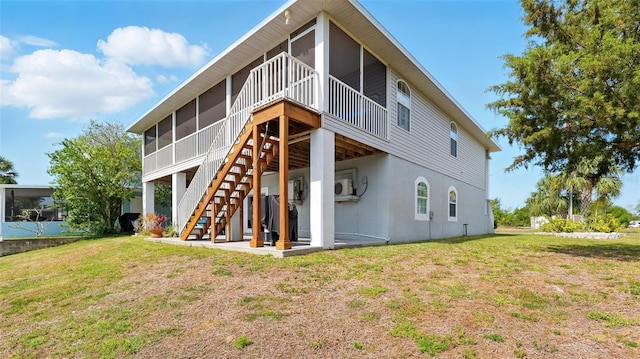 4396 5th Isle Dr, Hernando Beach, FL 34607 - rear view of property featuring a lawn, stucco siding, a sunroom, and stairway