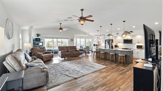 4396 5th Isle Dr, Hernando Beach, FL 34607 - living area with ceiling fan, vaulted ceiling, and light wood finished floors