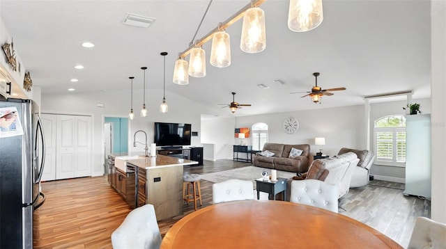 4396 5th Isle Dr, Hernando Beach, FL 34607 - dining space with vaulted ceiling, a healthy amount of sunlight, and light wood-style flooring