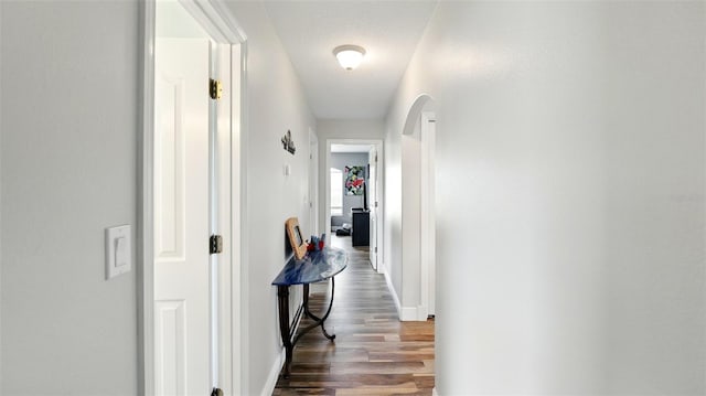 4396 5th Isle Dr, Hernando Beach, FL 34607 - hall featuring dark wood-style flooring, arched walkways, and baseboards