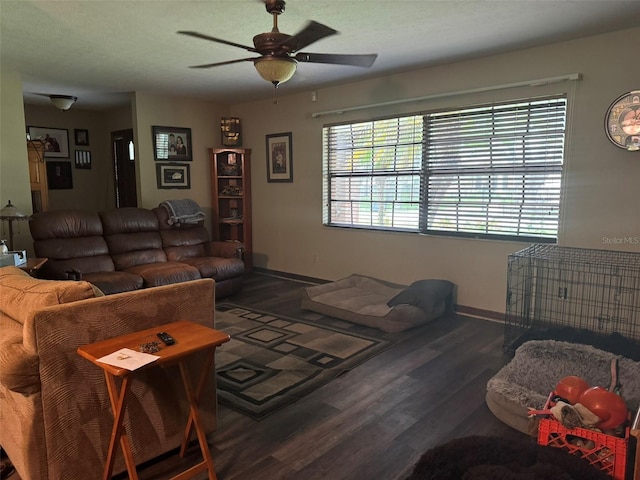 living room featuring a ceiling fan, baseboards, and wood finished floors
