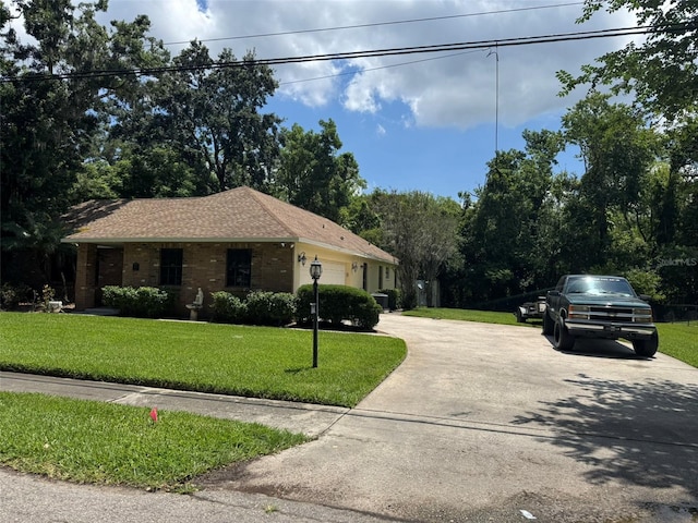 view of front of property featuring driveway, a front yard, and an attached garage