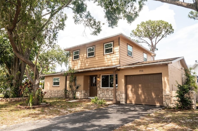 771 Murphy Ave N, Saint Petersburg, FL 33703 - view of front of property featuring stone siding, a garage, driveway, and stucco siding