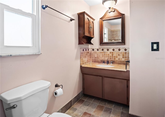 771 Murphy Ave N, Saint Petersburg, FL 33703 - bathroom featuring toilet, backsplash, vanity, and baseboards