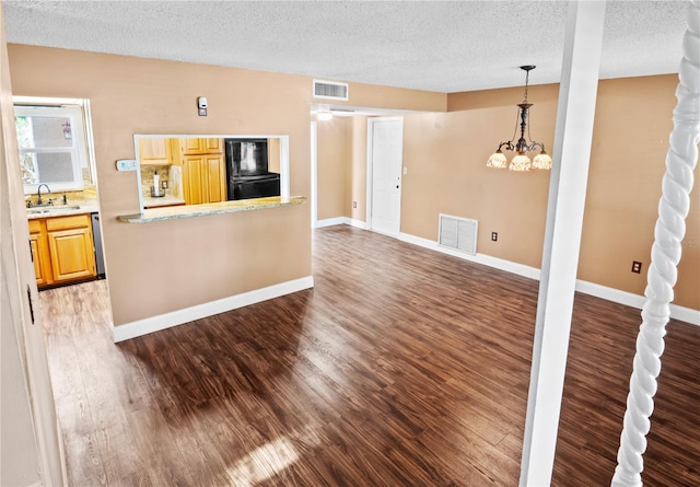 771 Murphy Ave N, Saint Petersburg, FL 33703 - unfurnished living room with a sink, wood finished floors, a textured ceiling, a chandelier, and baseboards