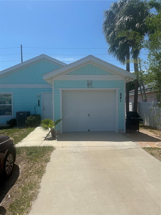 single story home featuring fence, cooling unit, concrete driveway, and an attached garage