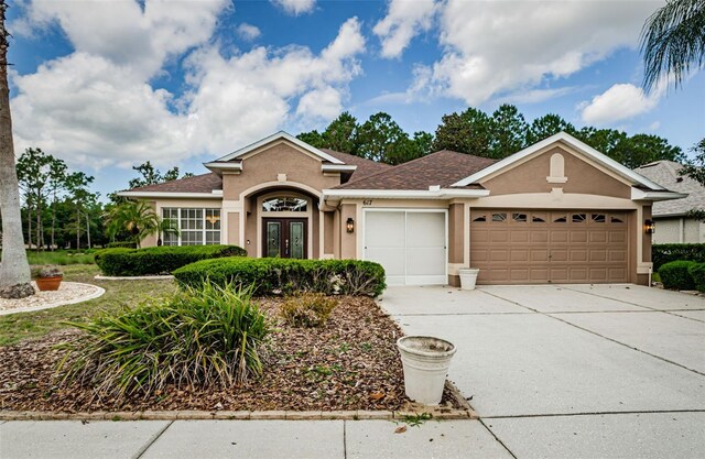 617 Glastonbury Ct, Spring Hill, FL 34609 - ranch-style house with french doors, stucco siding, an attached garage, driveway, and a shingled roof