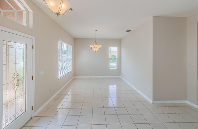 617 Glastonbury Ct, Spring Hill, FL 34609 - foyer entrance with a chandelier, healthy amount of natural light, light tile patterned floors, and baseboards