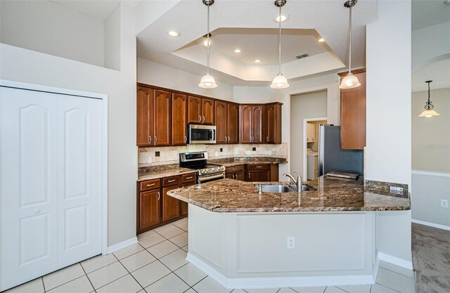 617 Glastonbury Ct, Spring Hill, FL 34609 - kitchen with appliances with stainless steel finishes, a sink, dark stone countertops, a raised ceiling, and recessed lighting