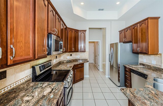 617 Glastonbury Ct, Spring Hill, FL 34609 - kitchen with appliances with stainless steel finishes, dark stone counters, and backsplash