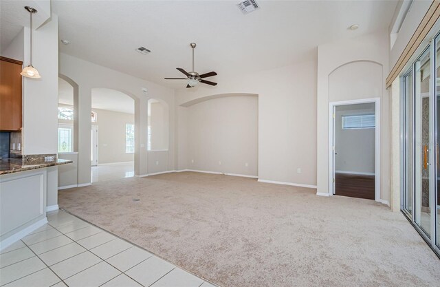 617 Glastonbury Ct, Spring Hill, FL 34609 - unfurnished living room featuring light colored carpet, ceiling fan, baseboards, and arched walkways