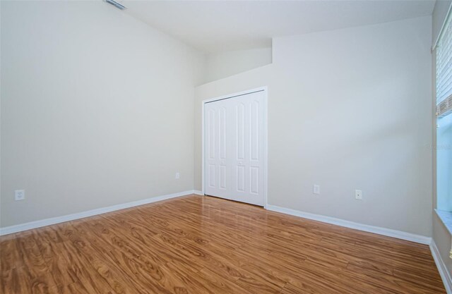 617 Glastonbury Ct, Spring Hill, FL 34609 - unfurnished bedroom featuring wood finished floors, a closet, and baseboards