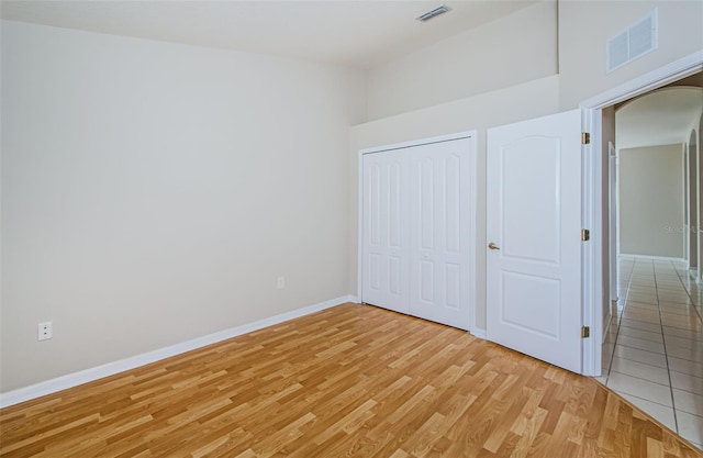617 Glastonbury Ct, Spring Hill, FL 34609 - unfurnished bedroom featuring light wood-style flooring, baseboards, arched walkways, and a closet