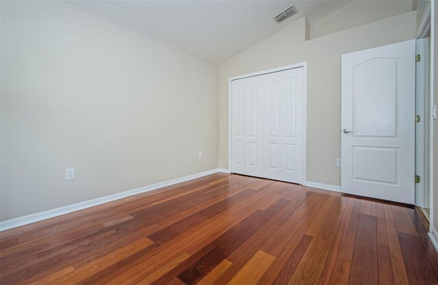 617 Glastonbury Ct, Spring Hill, FL 34609 - unfurnished bedroom featuring lofted ceiling, hardwood / wood-style floors, a closet, and baseboards
