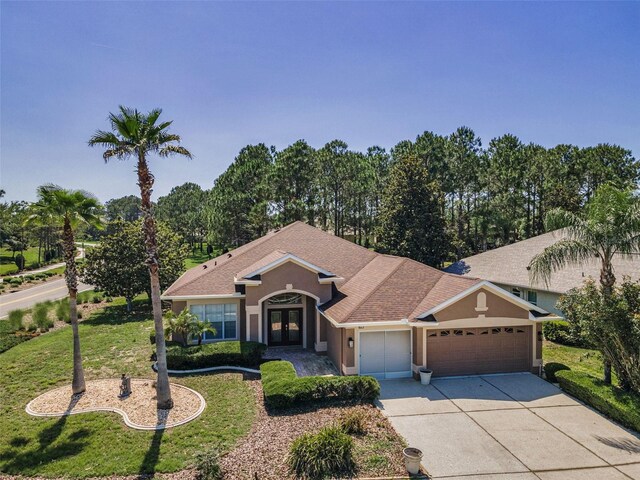 617 Glastonbury Ct, Spring Hill, FL 34609 - view of front of house with an attached garage, french doors, stucco siding, concrete driveway, and a front yard
