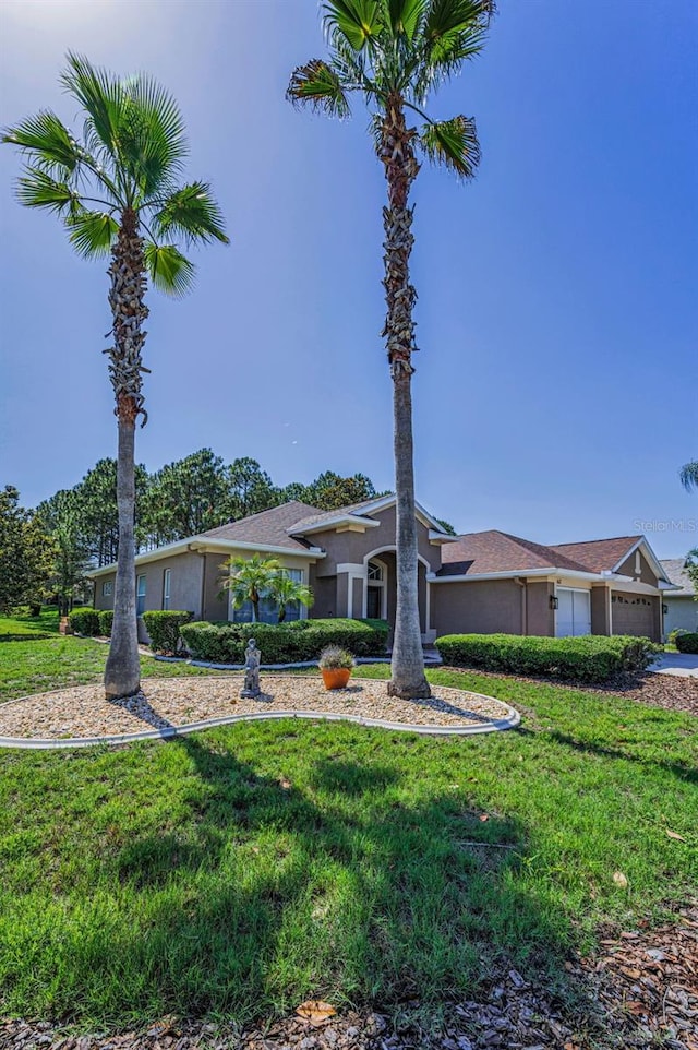 617 Glastonbury Ct, Spring Hill, FL 34609 - view of front facade with stucco siding, a front lawn, and a garage