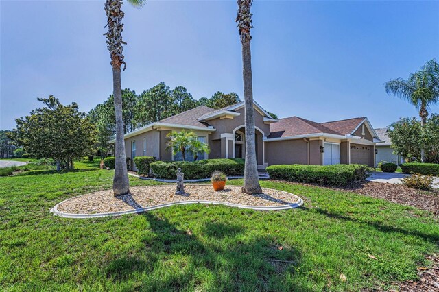 617 Glastonbury Ct, Spring Hill, FL 34609 - view of front of property with stucco siding, a front lawn, a garage, and driveway