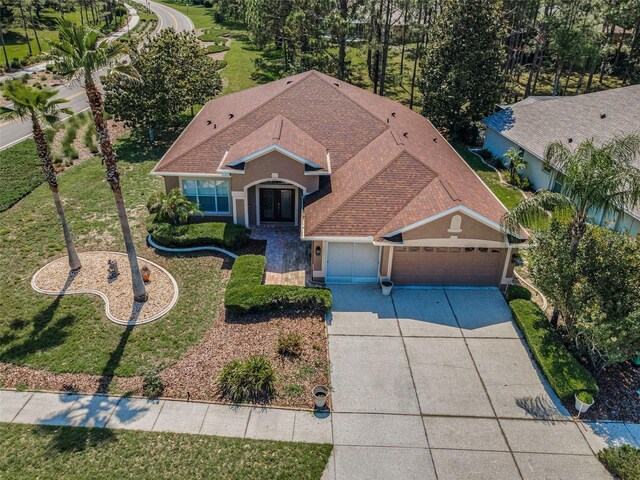 617 Glastonbury Ct, Spring Hill, FL 34609 - view of front facade featuring a garage, driveway, stucco siding, roof with shingles, and french doors