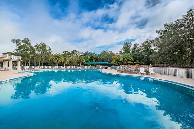 617 Glastonbury Ct, Spring Hill, FL 34609 - community pool featuring a patio, view of scattered trees, and fence