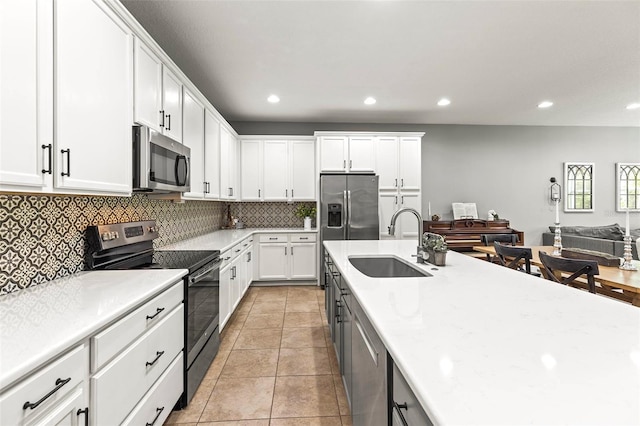 kitchen featuring light countertops, white cabinets, tasteful backsplash, a sink, and stainless steel appliances