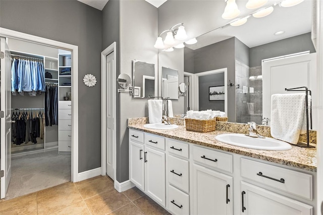 full bathroom featuring double vanity, a sink, a walk in closet, and a shower stall