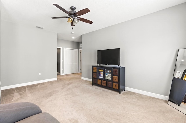 living room with a ceiling fan, baseboards, visible vents, and light carpet