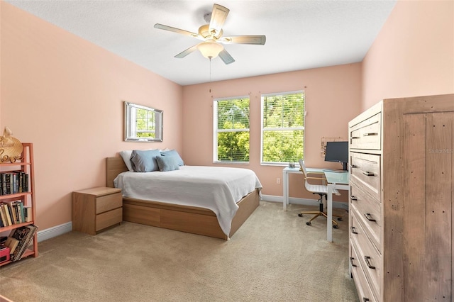bedroom with a ceiling fan, baseboards, and light colored carpet
