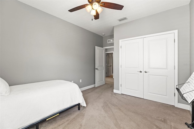 carpeted bedroom with a ceiling fan, baseboards, visible vents, and a closet