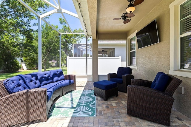 view of patio / terrace featuring an outdoor living space, a ceiling fan, and a lanai