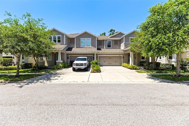 multi unit property featuring a garage, stucco siding, and concrete driveway