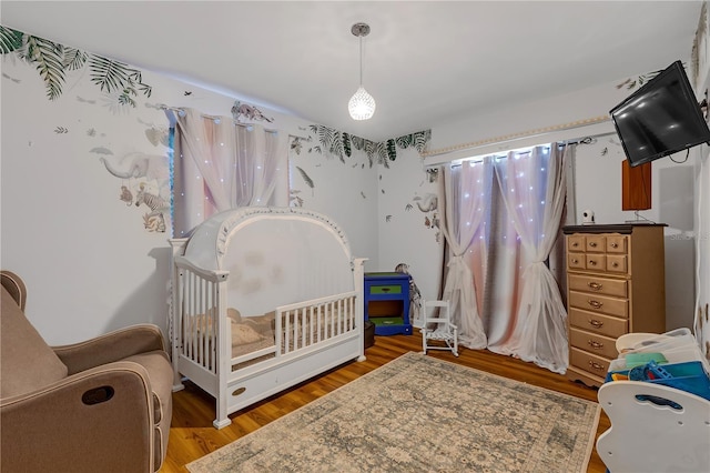 2014 E Broad St, Tampa, FL 33610 - bedroom with a crib and wood finished floors