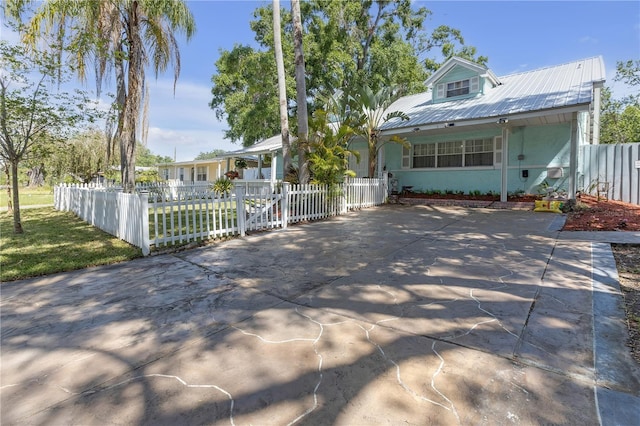 2014 E Broad St, Tampa, FL 33610 - view of front of home with a porch, a fenced front yard, metal roof, and stucco siding