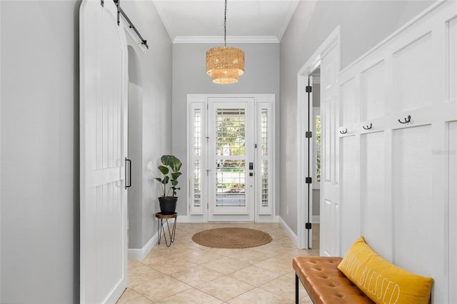 mudroom featuring light tile patterned floors, baseboards, a barn door, and ornamental molding