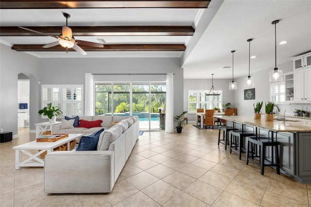 living room featuring beam ceiling, ceiling fan, recessed lighting, arched walkways, and light tile patterned floors