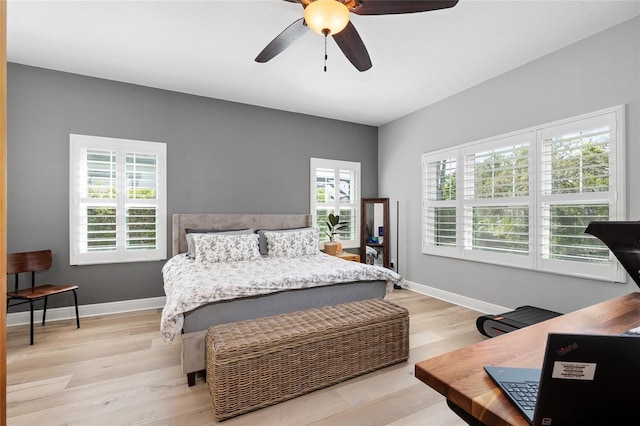 bedroom with baseboards, ceiling fan, and light wood-style flooring